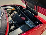a red car with a large engine in it ' s trunk