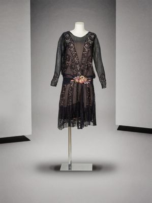 une robe noire posée sur un mannequin dans une pièce blanche