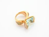 a close up of a gold ring with a green and white stone