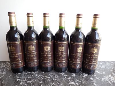 six bottles of wine are lined up in a row on a table