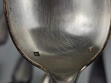 a close up of a spoon with a lot of spoons in the background