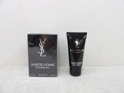 un flacon de crème pour les mains YSLM à côté d'une boîte noire