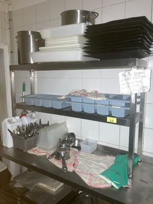 une étagère métallique avec des casseroles et des poêles dans une cuisine