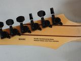 a close up of a guitar neck with a number of knobs on it