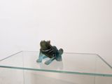 a figurine of a frog sitting on a glass table