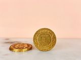 two gold coins sitting on top of a marble counter top