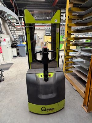 un chariot élévateur dans un entrepôt, avec des rayonnages à l'arrière-plan