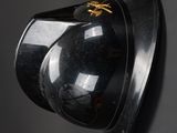 a helmet mounted on the wall with a gold bee on it