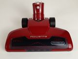a close up of a red vacuum cleaner on a white surface