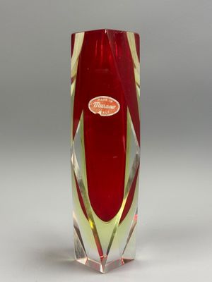 un vase rouge à bord doré sur fond blanc