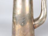 an antique silver plated coffee pot on a white background
