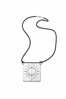 un gros plan d'un collier orné d'un soleil, sur fond blanc