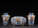 trois vases bleus et blancs posés les uns à côté des autres sur une surface noire