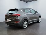 the rear end of a gray car in a white room