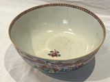 a white bowl with flowers on it on a table