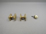 a pair of gold plated earrings and a pearl