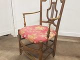 une image représentant une chaise avec un coussin rose posé dessus, dans une pièce