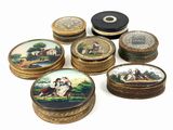 plusieurs petites boîtes rondes ornées de peintures, posées sur une surface blanche