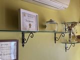 a glass shelf with a bowl on it in the corner of a room