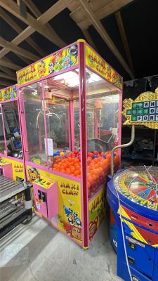 oranges in a pink cart next to an arcade machine