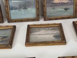 many framed pictures on the wall of a room