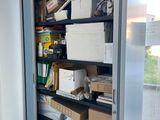 a tall metal cabinet with many boxes on top of it