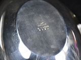 a close up of a silver plate with a black background