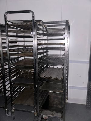 une étagère métallique sur laquelle sont posés plusieurs plateaux de nourriture