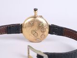 a gold watch with a black leather strap around it