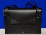 un sac en cuir noir sur lequel est posée une enveloppe