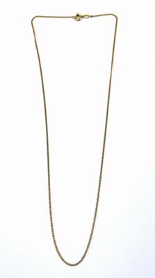 un collier en or avec une chaîne sur fond blanc