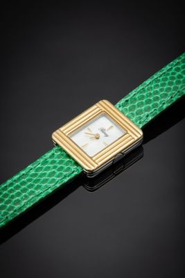 a close up of a wrist watch with a green strap