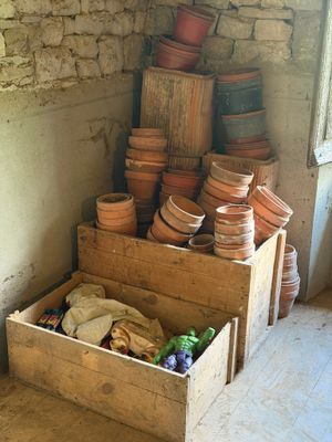 une pile de casseroles dans une caisse en bois, dans un coin de la pièce