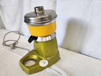a yellow blender sitting on a table next to a white sheet