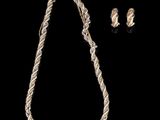 un ensemble composé d'un collier et de boucles d'oreilles en argent sur fond noir