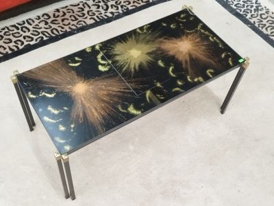 une table en verre ornée d'un motif noir et or