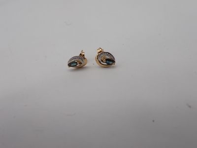 a pair of gold and diamond earrings on a white surface