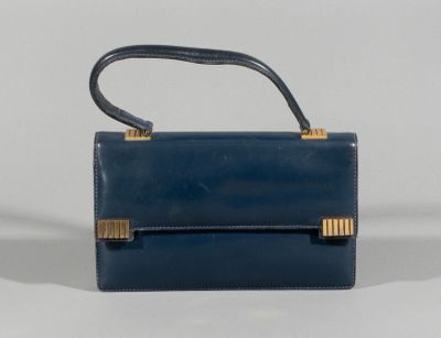 the small blue purse is sitting on a white surface