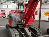 une pelleteuse rouge garée à l'intérieur d'un bâtiment