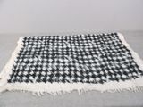 a black and white checkered blanket on a bed