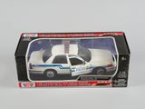 une petite voiture de police dans une boîte, posée sur une surface blanche