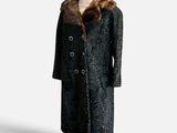 a black coat with a fur collar on a mannequin