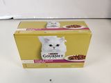 une boîte de nourriture pour chat posée sur un plan de travail blanc