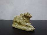 statue of a sheep on a rock on a black surface