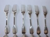 five forks and six spoons on a white table