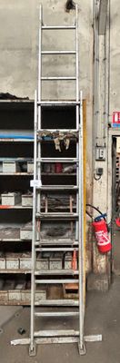 une échelle appuyée contre un mur à côté d'un immeuble