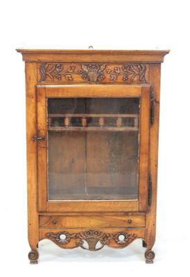 un vieux meuble en bois surmonté d'une porte en verre