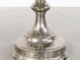 an antique silver plated candle holder with a candle on top of it