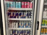 many cans of sodas and cans of soda in a refrigerator