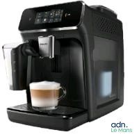 La machine à café est noire et contient une tasse de café.